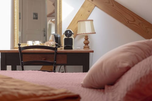 Chambre douillette du gîte Les Olivanies à Monthelon avec coiffeuse, lampe et miroir donnant sur l'espace mansardé