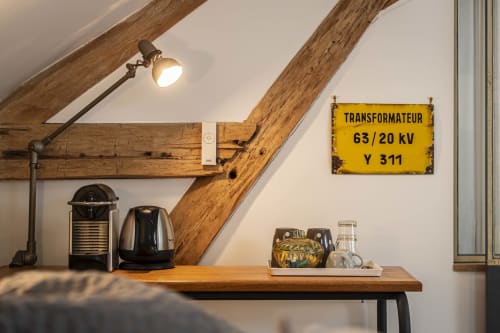 Chambre mansardée du gîte Les Olivanies à Monthelon avec poutres apparentes, cafetière et enseigne vintage