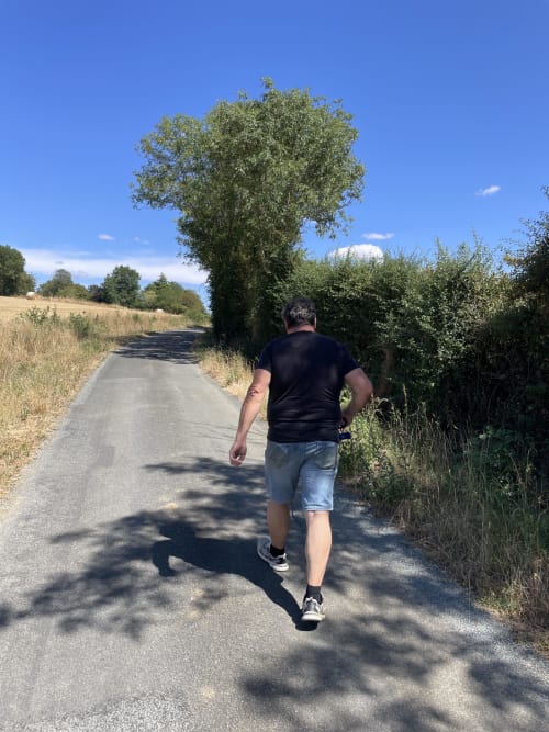 Homme en jogging sur une route rurale près de la maison d'hôtes Le Petit Moulin à Pouzauges, France