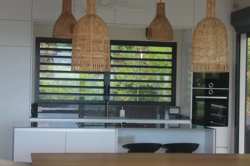 Cuisine contemporaine de la Villa Mahogany avec suspensions tressées, fenêtres noires, cabinetry blanc et vue sur mer