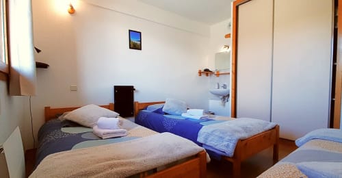 Chambre triple avec lits en bois au Chalet De La Yodine à Feissons sur Salins, salle de bains commune visible