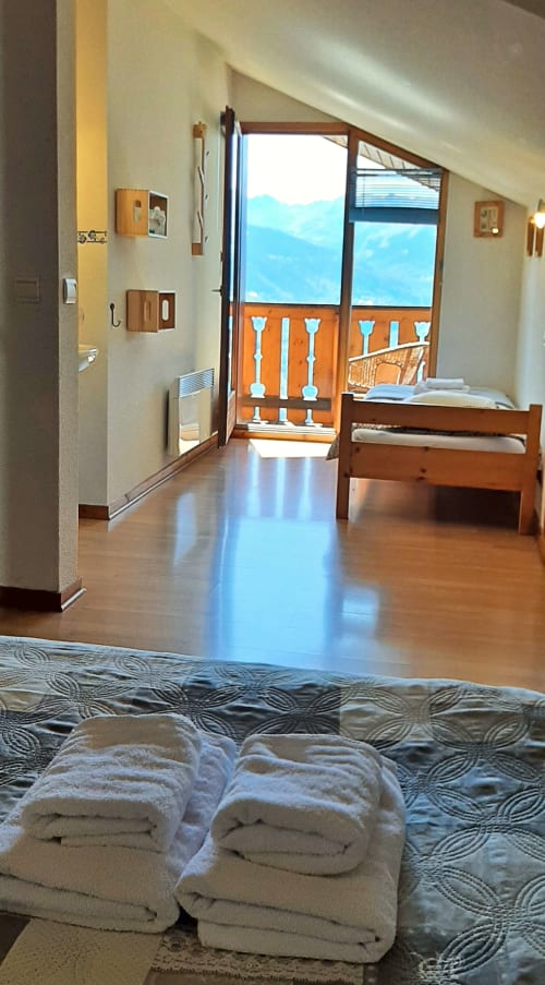 Chalet De La Yodine, chambre familiale avec balcon vue montagne, lits en bois, serviettes roulées et paysage alpin à Feissons sur