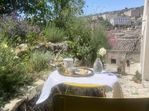Affascinante terrazza di villa a Modica con vista sulla città, tavolo elegante, fiori e storici edifici