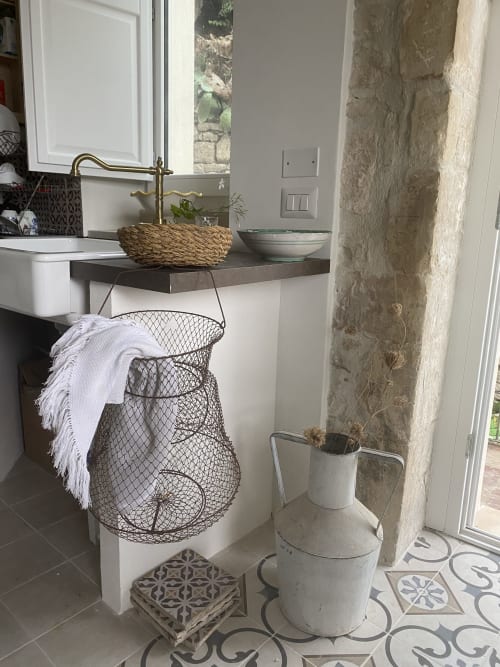 Lavandino rustico con bacile in vimini e rubinetto in ottone nella villa Lovelyloft di Modica