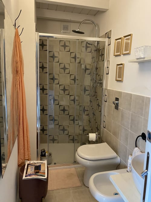 Bagno moderno nella villa Lovelyloft di Modica con box doccia in vetro, piastrelle decorate e finiture contemporanee