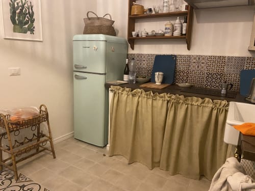 Frigorifero retrò verde menta nella cucina della villa Lovelyloft a Modica, con rivestimento decorato e ripiani in legno