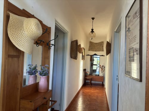 Corridoio della villa Lovelyloft a Scicli con pavimenti in cotto, porte in legno e illuminazione a sospensione