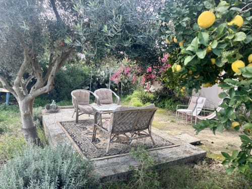 Patio del giardino mediterraneo di Lovelyloft a Scicli con limoni, sedute e buganvillea rosa