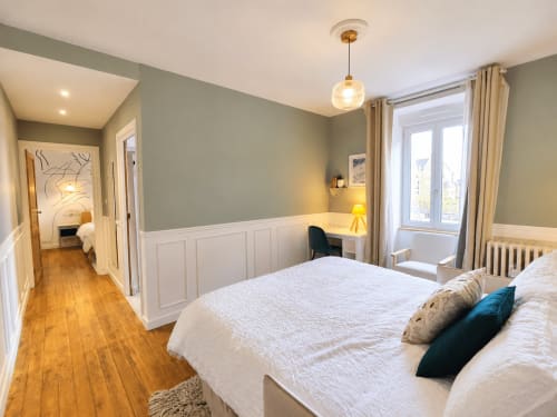 Chambre lumineuse aux Chambres D'Hespéris à Pleyben avec lits jumeaux, murs vert sauge, lambris blanc, parquets