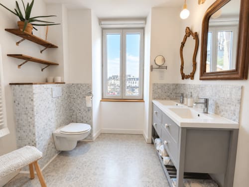 Salle de bains moderne aux Chambres D'Hespéris à Pleyben avec double vasque, carrelage mosaïque et vue sur la ville