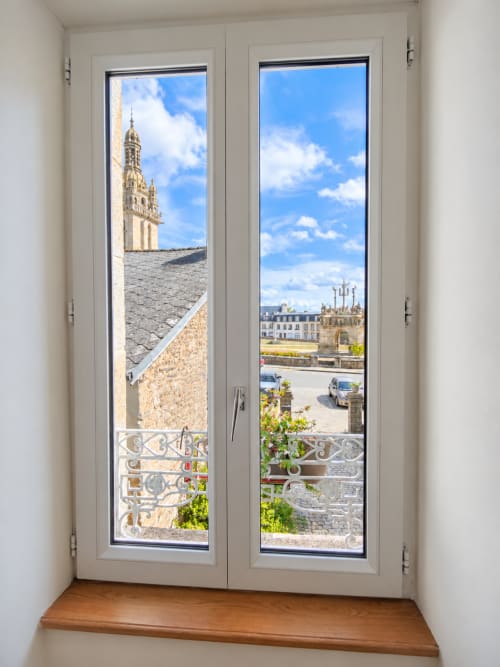 Vue de la chambre Aube aux Chambres D'Hespéris à Pleyben montrant le clocher de l'église et l'architecture historique