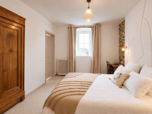 Chambre Aurore aux Chambres D'Hespéris à Pleyben avec lit, armoire en bois et vue sur les environs