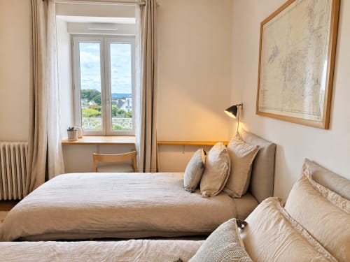 Chambre lumineuse aux Chambres D'Hespéris à Pleyben avec vue sur le jardin, lits jumeaux et bureau près de la fenêtre