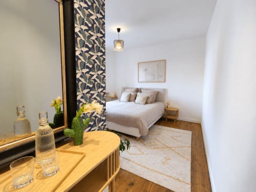 Chambre moderne aux Chambres D'Hespéris, Pleyben avec lit queen-size, coiffeuse en bois, mur d'accent à motifs et luminaires suspendus