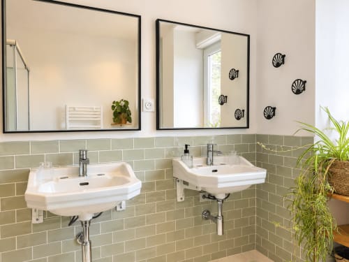 Salle de bains moderne aux Chambres D'Hespéris avec doubles vasques, carrelage subway vert sauge et décoration murale en coquillages
