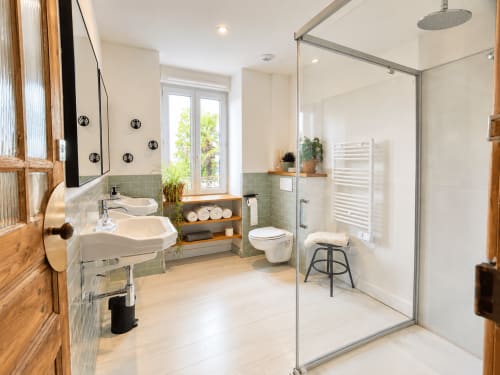 Salle de bains moderne aux Chambres D'Hespéris à Pleyben avec double vasque, douche à l'italienne et vue sur le jardin