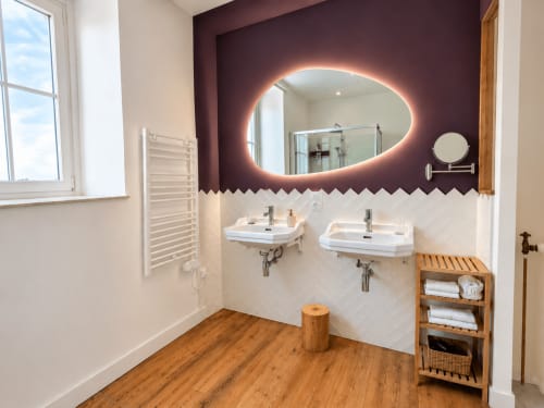 Salle de bains moderne aux Chambres D'Hespéris à Pleyben avec vasque double, miroir éclairant et touches de bois