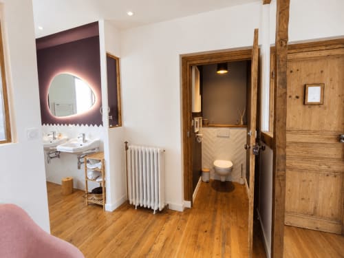 Salle de bains de la chambre Solstice aux Chambres D'Hespéris à Pleyben, avec miroir rétroéclairé et portes en bois