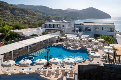 Terrazza piscina lussuosa del Villa Bina Sea Hotel con vista sulla costa di Serrara Fontana, ombrelloni e lettini