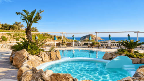 Lussuosa area piscina del Villa Bina Sea Hotel con acqua turchese, palme e vista sul Mar Mediterraneo a Serrara Fontana