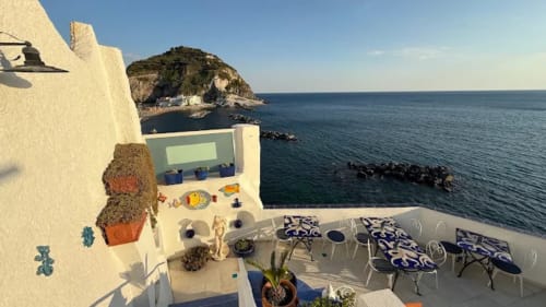 Terrazza del Villa Bina Sea Hotel con vista sulla costa rocciosa e il Mar Mediterraneo a Serrara Fontana, Italia