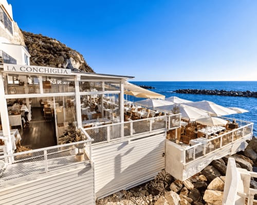Ristorante La Conchiglia con terrazze bianche affacciate sul mare blu presso la Villa Bina Sea Hotel, Serrara Fontana
