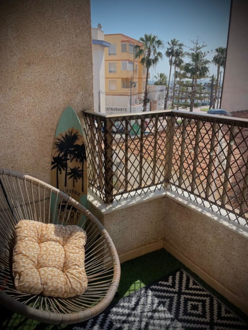 Zona de estar en balcón del apartamento La Casita del Mar en San Pedro del Pinatar con palmeras y vistas al mar