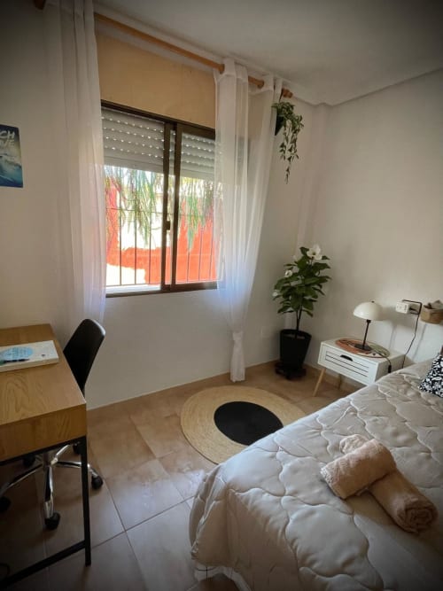 Dormitorio luminoso con vista al mar en La Casita del Mar, San Pedro del Pinatar, con cama, escritorio y plantas