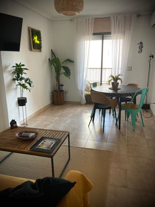 Sala de estar moderna con comedor, balcón con vista al mar, plantas y muebles contemporáneos en San Pedro del