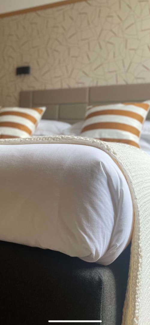 Almohadas rayadas y ropa de cama blanca en la Chambre Cannelle de Les 15 Chenes B&B, Saint-Mesmin, Francia