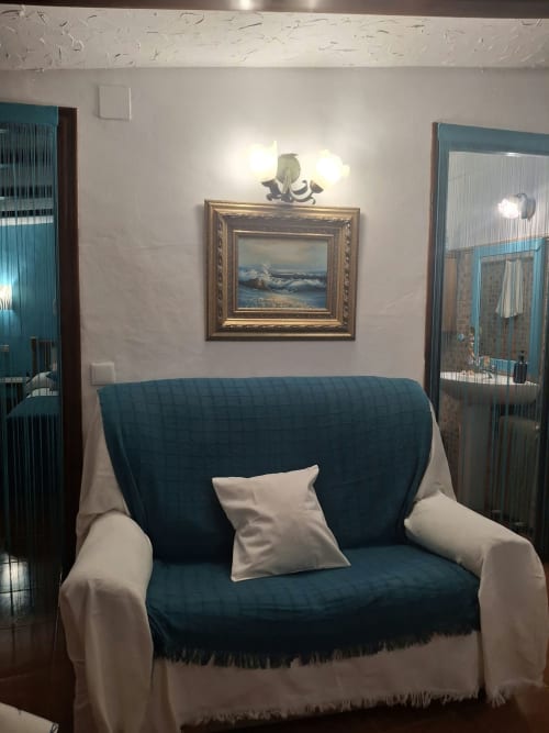 Cozy seating area in El mirador apartment at Refugio la Presa, Chulilla with navy blue and white armchair and framed coastal