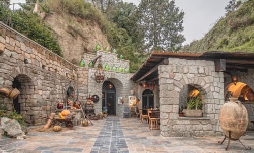 Cortile dell'Hotel Villa Bina Sea a Serrara Fontana con arcate in pietra, decorazioni autunnali e architettura rustica mediterranea
