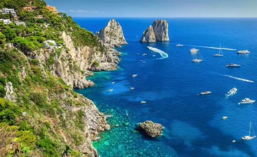 Suggestiva costa di Capri con acque turchesi, scogliere calcaree e barche a vela presso Villa Bina Sea Hotel, Serrara Fontana