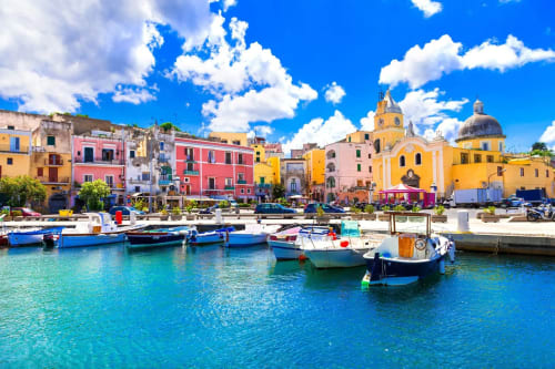 Affascinante villaggio costiero di Serrara Fontana con edifici colorati, barche e acque cristalline turchesi sotto il cielo azzurro