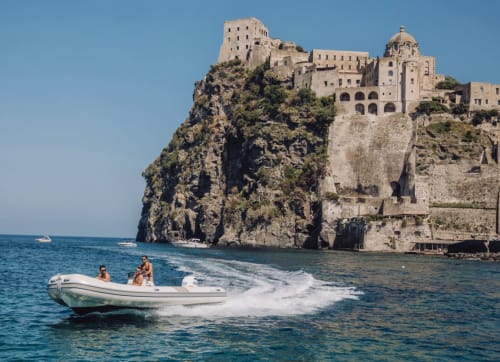 Motoscafo con ospiti vicino al castello a picco sul mare di Villa Bina Sea Hotel, Serrara Fontana, Italia