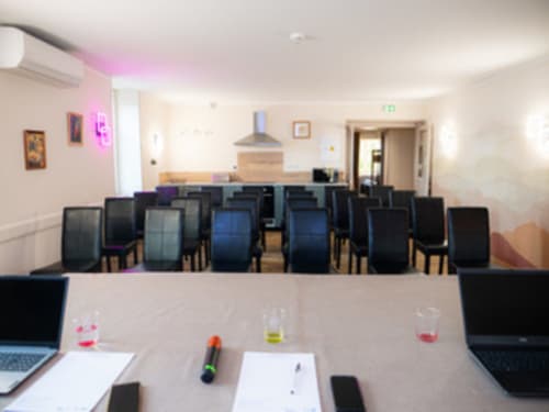 Salle de conférence moderne aux Gites Les Muriers à Bourgvilain avec coin repas, cuisine et éclairage néon