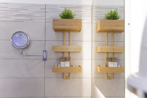 Mensola moderna del bagno con organizzatori in legno, piante in vaso e amenities presso Aurum Nolana Suites a Pompei