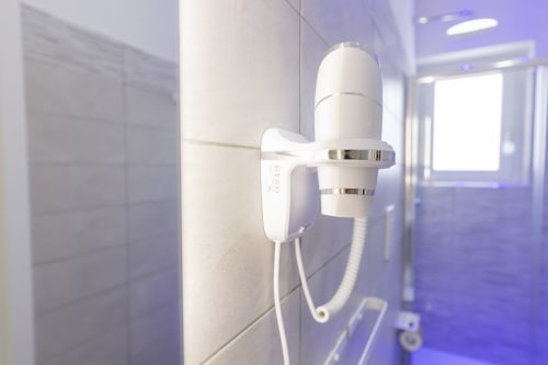 Asciugacapelli a parete nel moderno bagno dell'hotel Aurum Nolana Suites a Pompei