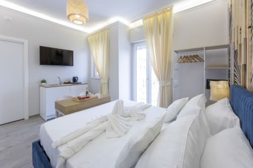 Suite con letto matrimoniale di lusso presso Aurum Nolana Suites a Pompeii, balcone, vista sulla città e servizi moderni