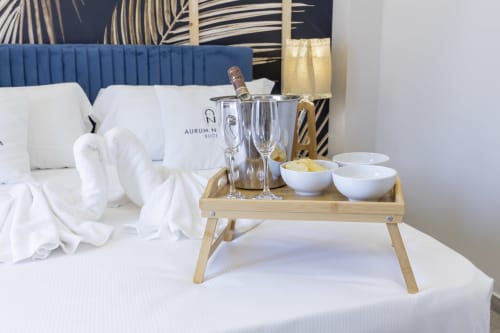 Benvenuto champagne su vassoio di legno nella suite deluxe Aurum Nolana con testata blu