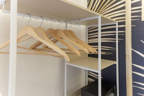 Appendiabiti in legno sulla barra dell'armadio nella suite deluxe di Aurum Nolana Suites, Pompei