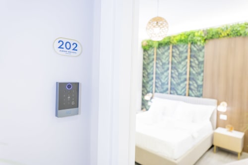 Camera 202 presso Aurum Nolana Suites a Pompei con accesso a tastiera digitale, letto con vista sul Vesuvio e comfort moderni
