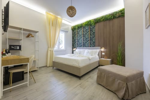 Camera moderna Aurum Nolana Suites a Pompei con letto queen, carta da parati con vista montagna, scrivania e design contemporaneo