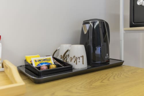 Angolo caffè con bollitore elettrico, tazze e tè Bonomelli nella suite dell'hotel Aurum Nolana a Pompei