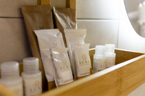 Esposizione di lussuosi articoli da bagno e amenities presso l'Aurum Nolana Suites di Pompei, con prodotti branded e finiture color crema