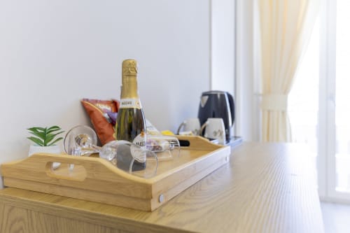 Vassoio di benvenuto in legno con champagne Moscato, calici e pianta grassa nella suite Aurum Nolana di Pompeii