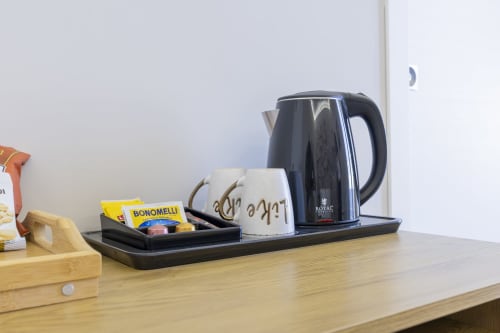 Bollitore elettrico e set da caffè su vassoio nero nella suite Aurum Nolana di Pompei, con vista montagna