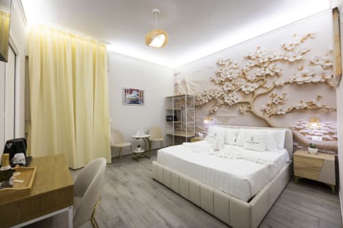 Lussuosa camera da letto con letto king-size alle Aurum Nolana Suites a Pompeii, con eleganti decorazioni floreali dorate, biancheria bianca e vista sul Vesuvio