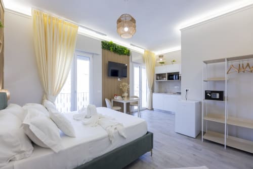Suite Esecutiva Tripla Aurum Nolana a Pompei con letto moderno, angolo cottura, TV, balcone e vista montagna