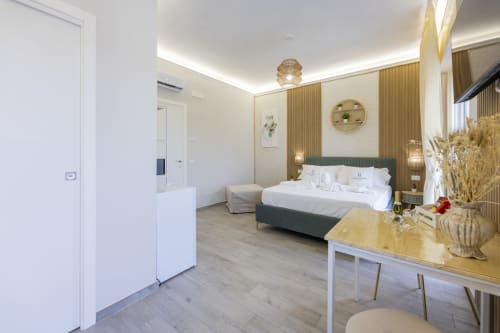 Suite tripla Executive presso Aurum Nolana Suites a Pompeii con arredi moderni, vista montagna e design contemporaneo